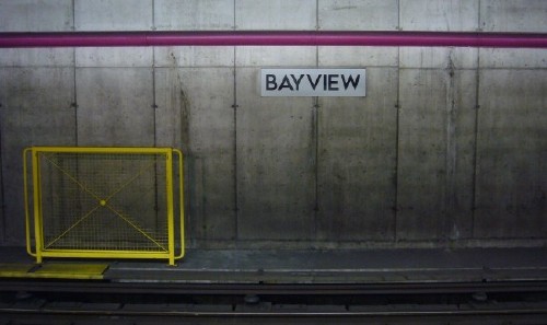 Sign on concrete wall under fuchsia line reads BAYVIEW