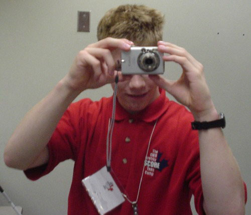 Boy in red shirt aims digicam at us