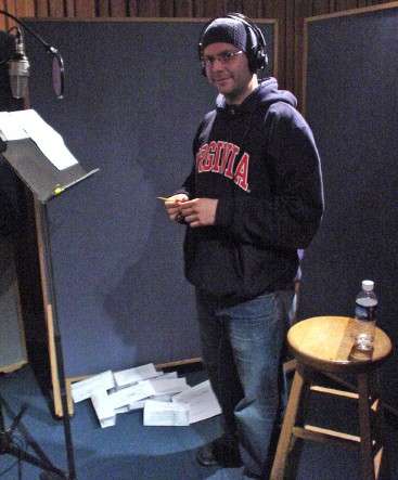 Jeremy Harris, wearing headphones, a skullcap, and sweatshirt, stands at a podium