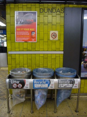 DUNDAS station is labelled in Univers, with framed advertisement on a wall and three garbage cans labelled in Futura Condensed