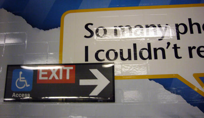 Exit sign sits amid a sea of giant advertising copy