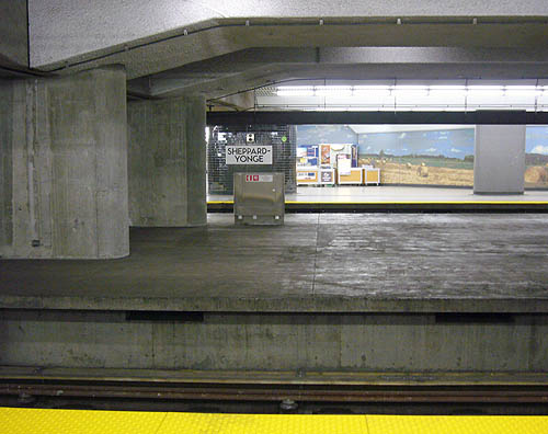 Tiny SHEPPARD-YONGE sign is distantly visible across several concrete platforms