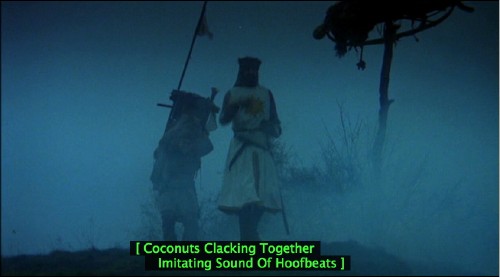 Scene shows King Arthur and Patsy on a misty moor with the caption [ Coconuts Clacking Together Imitating Sound of Hoofbeats ]