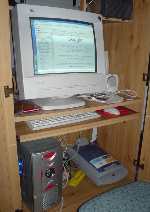 Monitor, keyboard, system unit, and HP scanner sit inside cupboard