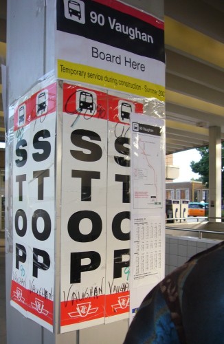 Pillar has preprinted sign with red line across the top reading 90 Vaughan Board Here, and four STOP signs with handwritten words 90 Vaughan