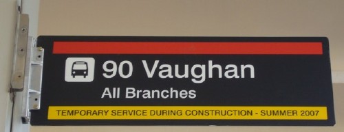 Black sign has red banner across top and reads 90 Vaughan All Branches in ‘Helvetica.’ Yellow line at bottom has reversed type reading TEMPORARY SERVICE DURING CONSTRUCTION - SUMMER 2007