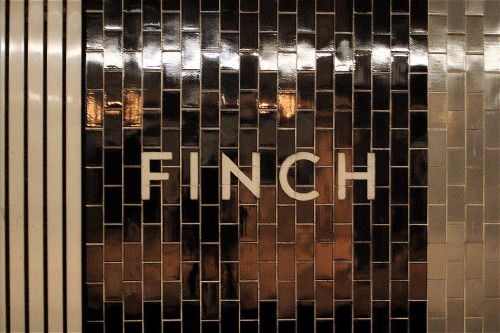 Letters blasted into deep bronze-brown tiles read Finch
