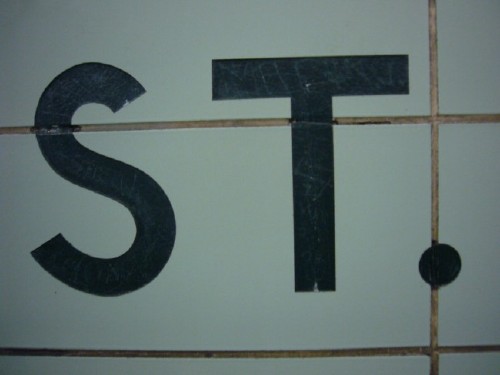 Letters ST are inscribed into green tile
