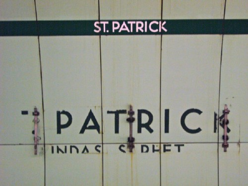 Strapline reads ST. PATRICK in intact type. Wall sign reads PATRIC and another line, all in broken type