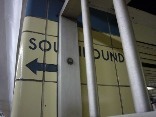 SOUTHBOUND sign sandblasted into wall sits behind metal fence members