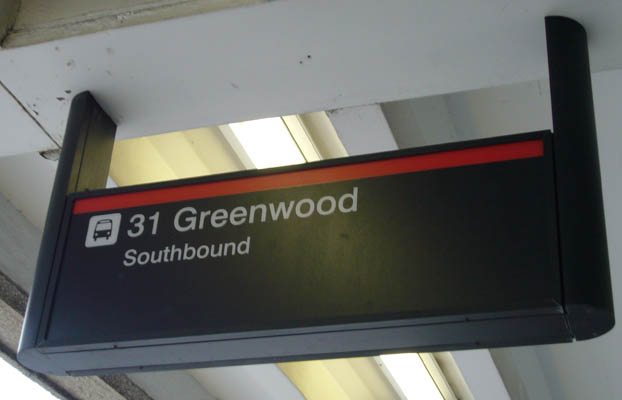 Black sign with red line across top reads 31 Greenwood Southbound