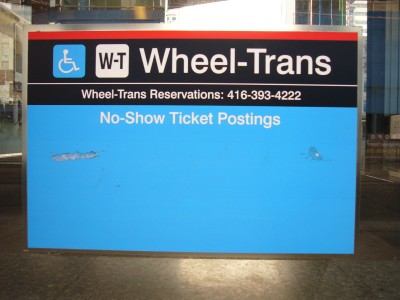 Wheel-Trans sign has top third in black with white type, bottom two-thirds in blue with white type