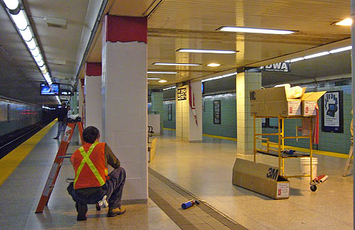 3M boxes sit on cart as a man in a safety vest tends to a white-and-red-covered column