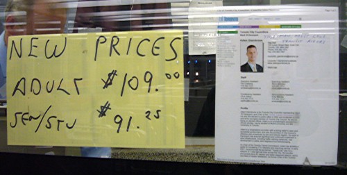 Handwritten sign lists new fare prices. Printed sign with handwritten line sits alongside it