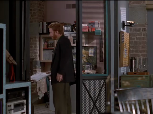 Elliot next to inside door jamb, with mesh lower panel criscrossed by black struts