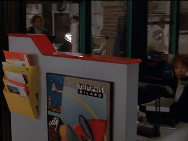 Partition wall features “Memphis Milano” artwork, bright yellow file-folder holders