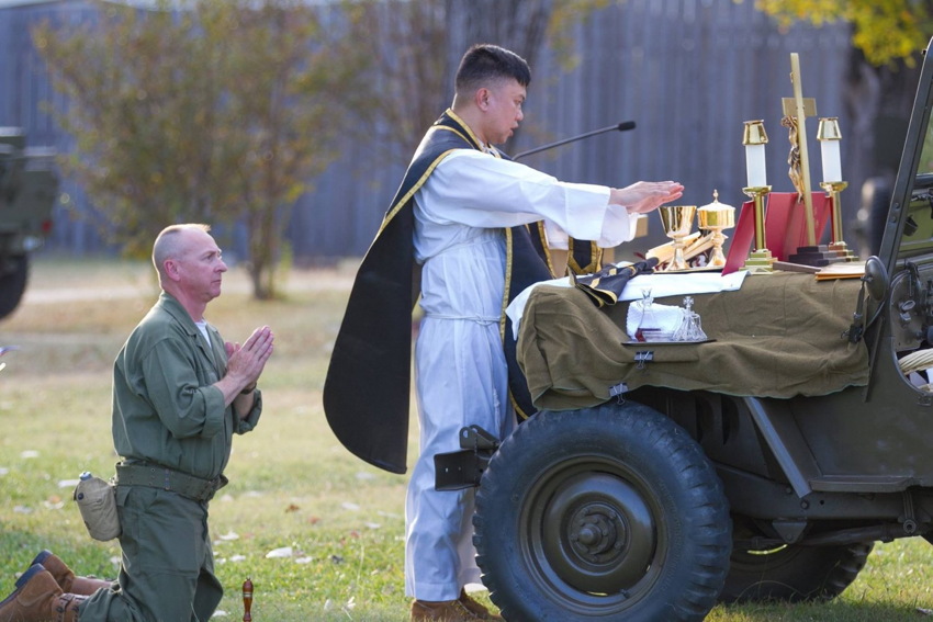 Consecration during Latin mass on hood of Jeep